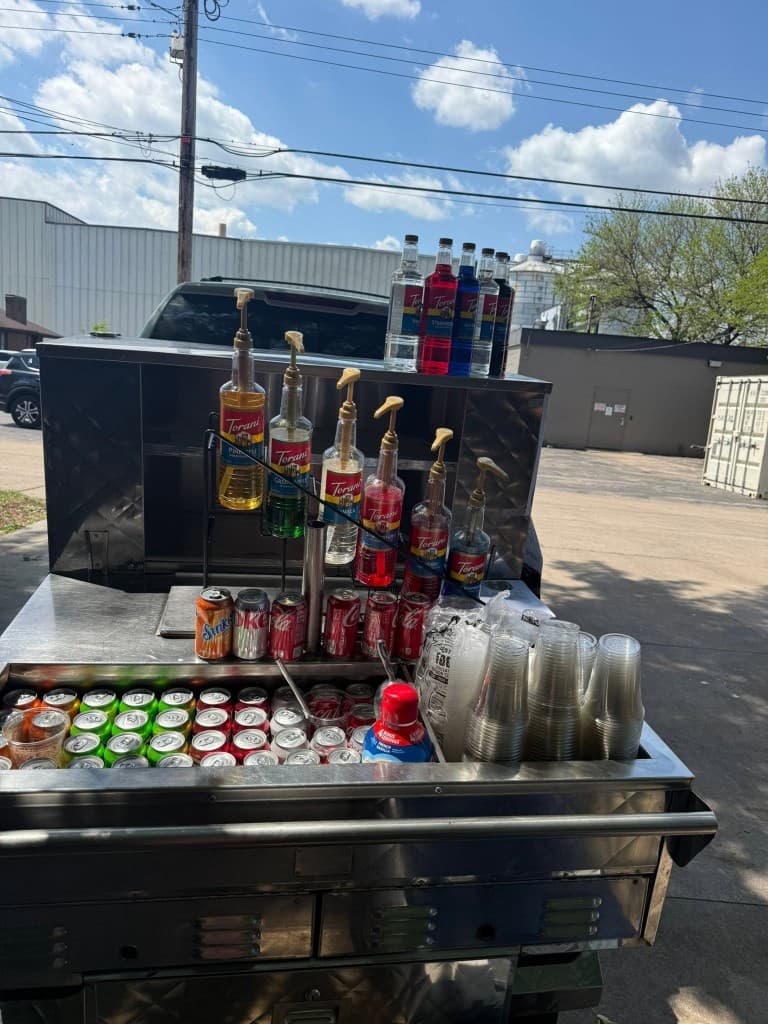 Stainless steel mobile soda cart with flavor syrups and canned sodas