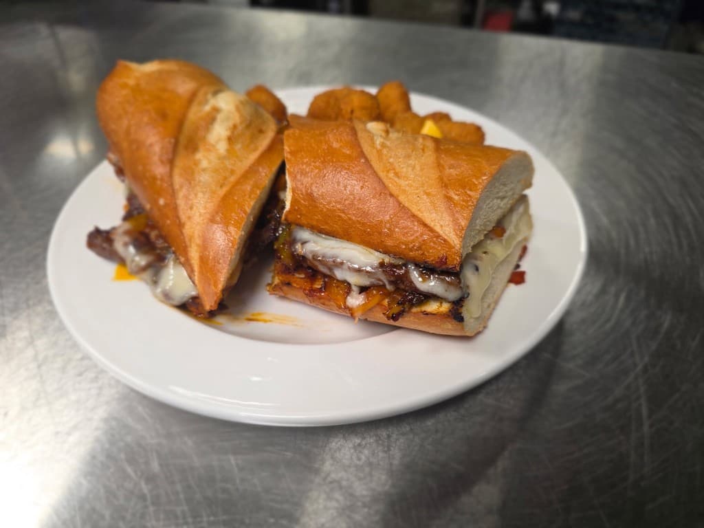 Toasted steak and cheese sandwich with melted cheese on a fresh roll